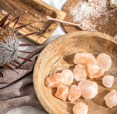 Spa composition with pieces of sea salt in a wooden plate, health and beauty concept.